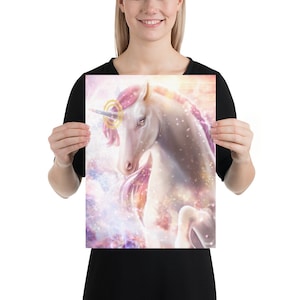 Puede incluir: Un unicornio blanco con una crin y cola rosadas se encuentra sobre un fondo de galaxia colorido. El unicornio tiene un halo dorado alrededor de la cabeza y un solo cuerno.