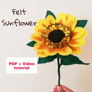Peut inclure: Un projet de bricolage de tournesol en feutre avec une fleur jaune et orange et des feuilles vertes. L'image comprend le texte "Felt Sunflower" et "PDF + Video tutorial".