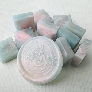 Paquete de perlas de cera translúcidas de color rosa azulado, suministro para sellar sellos, puesta de sol en el lago a principios de primavera.