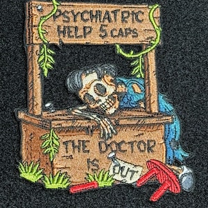 May include: Embroidered patch featuring a skeleton in a well, with the text "PSYCHIATRIC HELP 5 CAPS" above and "THE DOCTOR IS OUT" below. The well is brown with green vines and grass.