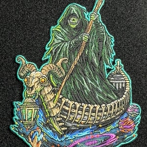 May include: Embroidered patch featuring the Grim Reaper in a hooded cloak, holding a staff, and sailing in a skeletal boat. The boat has a ram's skull figurehead and a lantern. The design includes cosmic elements with vibrant colors and a black background.