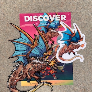 May include: Embroidered dragon patch with blue wings and orange accents, alongside a sticker of the same design. A book cover with the word "DISCOVER" and the text "A CJ WELLS TALE" is visible in the background.