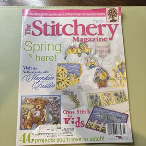 May include: The Stitchery Magazine cover with the headline "Spring is here!" and various cross-stitch projects. The magazine features a variety of spring-themed cross-stitch patterns, including flowers, animals, and Easter designs. The cover also includes the text "Cross Stitch for Kids."