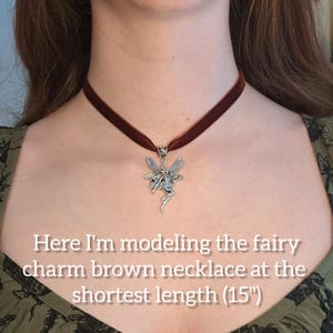 K&ouml;nnte beinhalten: Eine braune Samt-Chokerkette mit einem silbernen Feen-Anh&auml;nger. Die Kette ist in ihrer k&uuml;rzesten L&auml;nge von 15 Zoll dargestellt.