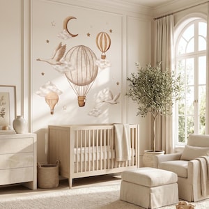Könnte beinhalten: Ein Wandaufkleber-Set mit beigen und braunen Illustrationen von zwei Heißluftballons, einer Mondsichel, Wolken, Sternen und zwei fliegenden Vögeln. Die Motive sind auf einer hellen Wand über einem hölzernen Kinderbett angeordnet.