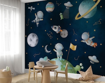 May include: A dark blue wallpaper with a space theme. It features astronauts, planets, stars, a rocket, a UFO, and a moon. The wallpaper is perfect for a child's room.