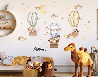 May include: A nursery wall decal set featuring three hot air balloons with animal passengers. The balloons are in shades of green, yellow, and blue, with white clouds and stars in the background. The text "Pattern 1" is visible at the bottom of the image.