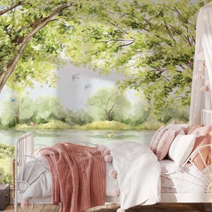 May include: A bedroom scene with a white metal bed, adorned with pink and white bedding, and a matching canopy. The backdrop is a watercolor mural of a serene forest scene with a lake and trees. A gray trunk and star-shaped light add to the decor.