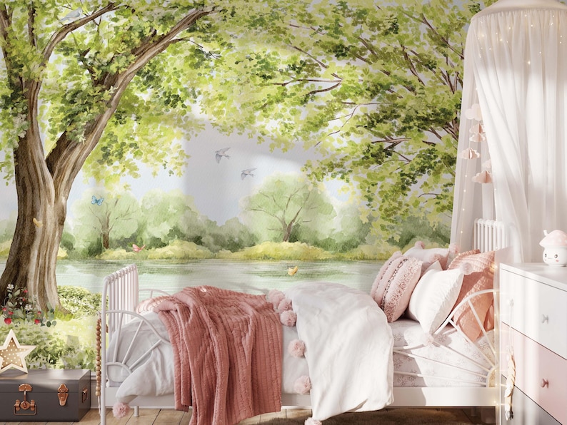 May include: A bedroom scene with a white metal bed, adorned with pink and white bedding, and a matching canopy. The backdrop is a watercolor mural of a serene forest scene with a lake and trees. A gray trunk and star-shaped light add to the decor.
