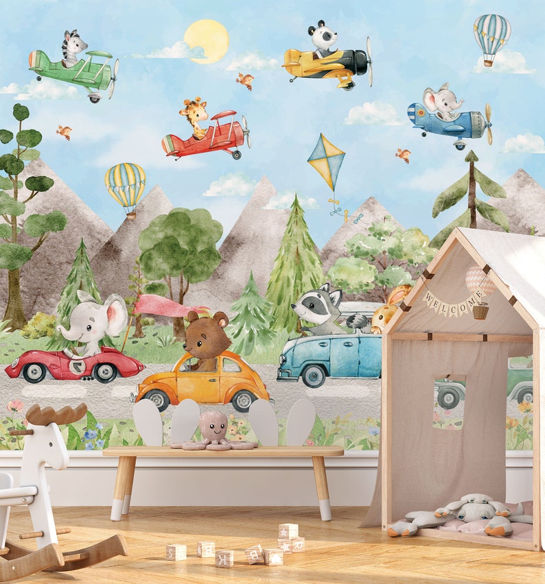 May include: A colorful children's room mural featuring animals driving cars and flying airplanes. The mural includes a giraffe, zebra, panda, raccoon, bear, and elephant. The mural is set against a backdrop of mountains, trees, and a blue sky. The text "Welcome" is displayed on a small wooden playhouse.