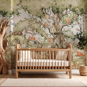 Puede incluir: Una cuna de madera con un colch&oacute;n blanco se encuentra frente a un mural caprichoso con tem&aacute;tica de bosque. El mural presenta ilustraciones de acuarela de criaturas del bosque, &aacute;rboles y una casa de hadas.