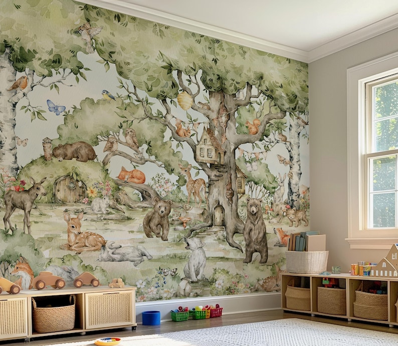 Op de afbeelding: Een aquarelmuurschildering die een fantasierijke bossc&egrave;ne voorstelt met een grote boom, een vogelhuisje en verschillende bosdieren, waaronder herten, beren en eekhoorns. De muurschildering is geschilderd in tinten groen, bruin en blauw, en heeft een lichtblauwe achtergrond.