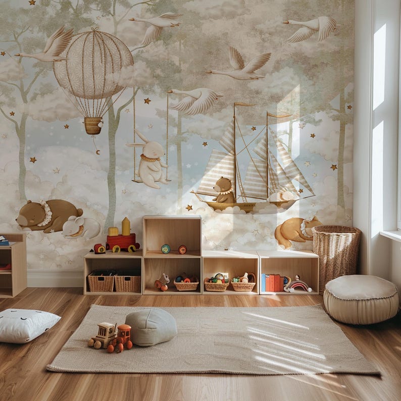 Op de afbeelding: Een kinderkamer met een muurschildering met een luchtballon, een zeilboot en dierenfiguren. Houten opbergkubussen, een vloerkleed en speelgoed maken de sc&egrave;ne compleet. Het kleurenpalet omvat zachte bruintinten, blauw en cr&egrave;me.