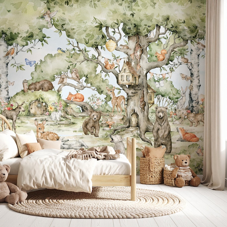 Puede incluir: Una habitaci&oacute;n infantil con una cama de madera clara, ropa de cama blanca y una alfombra redonda tejida. El tel&oacute;n de fondo es un mural detallado del bosque con osos, ciervos y una casa en el &aacute;rbol. Tambi&eacute;n hay un oso de peluche.