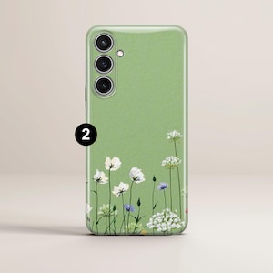 May include: A light green phone case with a floral design. The case features a field of white, purple, and green flowers along the bottom edge. The number "2" is printed in black on the upper left corner.