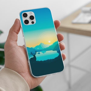 May include: A clear phone case with a blue and green landscape design. The design features a lake, mountains, and a deer silhouette. The phone case is being held in a hand.