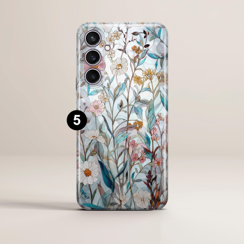 May include: A smartphone case with a floral design. The case features a light blue background with a pattern of flowers in shades of pink, white, yellow, and green. The number "5" is printed in black on the case.