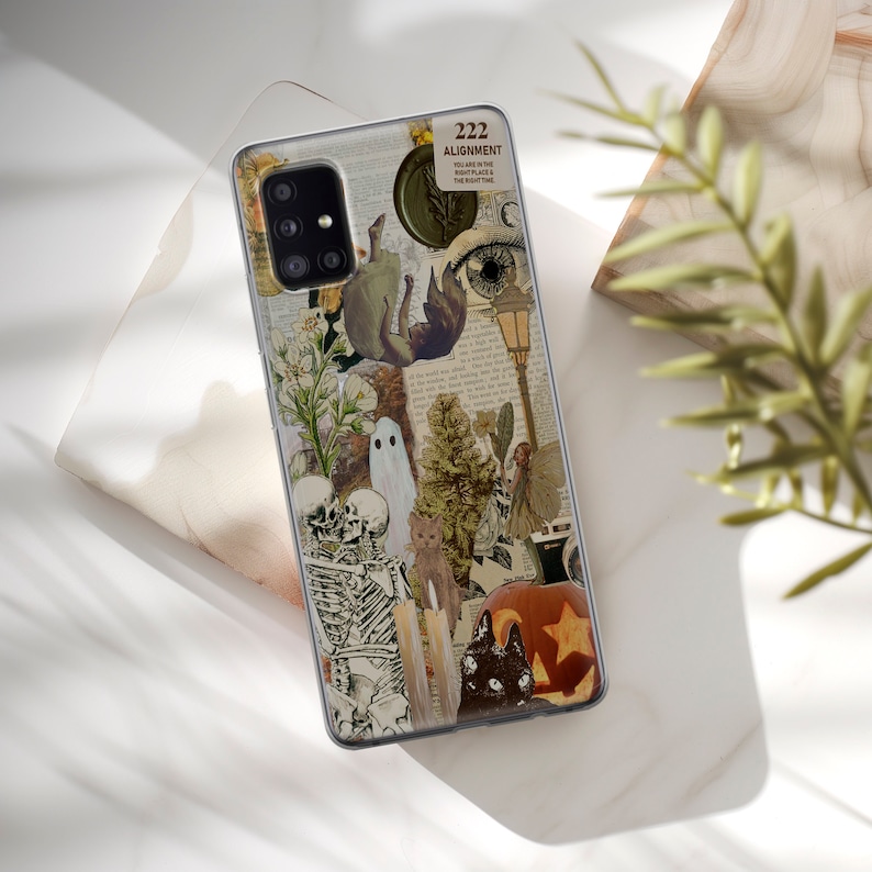May include: A clear phone case with a collage of images including a skeleton, a ghost, a cat, a pumpkin, and a fairy. The text "222 Alignment" is visible on the case.
