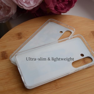 May include: Clear, ultra-slim and lightweight phone case. The case is transparent with a white interior and features the text "Ultra-slim & lightweight". The case has cutouts for the camera and other phone features.