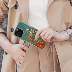 May include: A clear phone case with a skeleton and flowers printed on it. The case is designed for an iPhone.