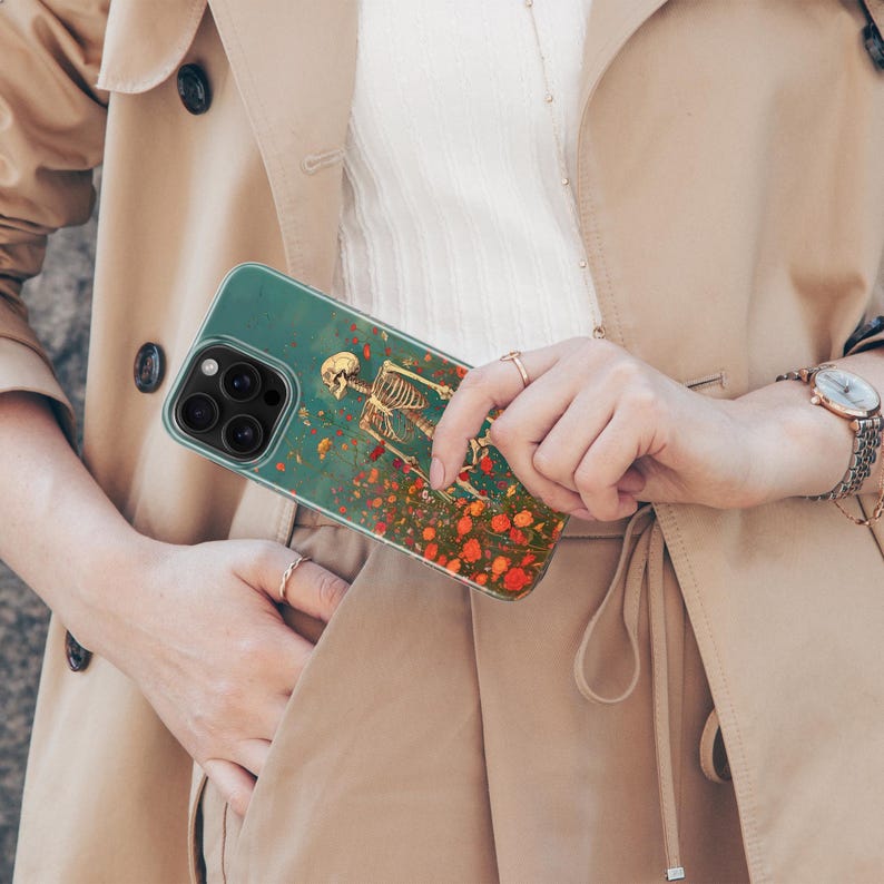 May include: A clear phone case with a skeleton and flowers printed on it. The case is designed for an iPhone.