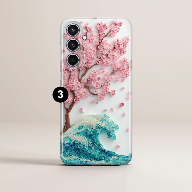 May include: A phone case featuring a detailed design of a cherry blossom tree with pink flowers and a blue and white wave. The case has a clear background and a camera cutout.