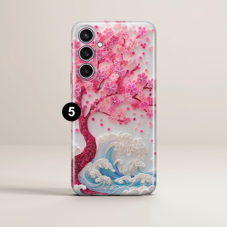 May include: A phone case featuring a pink cherry blossom tree design with white waves at the base. The case has a clear background and a glossy finish. The tree has a red trunk and branches with pink flowers.