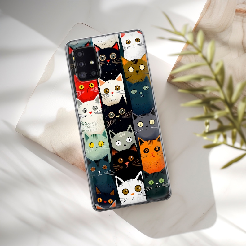 May include: A clear phone case with a colorful pattern of cats. The cats are all different colors and have different expressions on their faces. The case has a cutout for the camera lens.