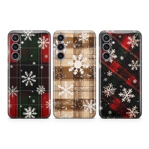 May include: Three phone cases with a winter plaid pattern and snowflake designs. The cases are in red, green, and brown.