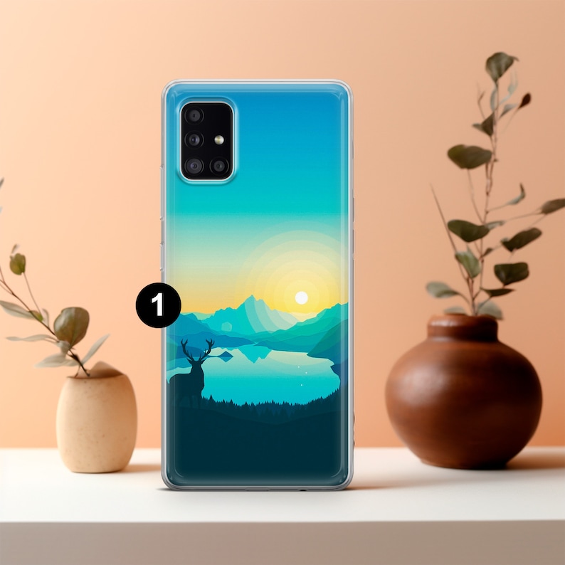 May include: A clear phone case with a colorful landscape design featuring a lake, mountains, and a deer silhouette. The sun is setting over the mountains.