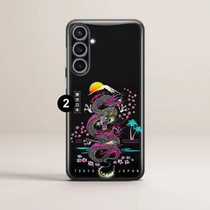 Pu&ograve; includere: Custodia per telefono nera con un design di drago colorato, una montagna e fiori di ciliegio. Il testo "Tokyo Japan" &egrave; nella parte inferiore della custodia. Il testo "2 東京日本" &egrave; nell'angolo in alto a sinistra della custodia.