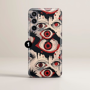 May include: A phone case with a black and white design featuring multiple red eyes. The eyes are drawn in a graphic style and appear to be dripping with blood.
