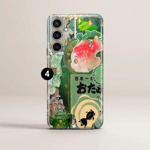 May include: A green and white phone case with a collage of images, including a red fish, a teapot, and Japanese text. The text reads "日本一の おたまで"