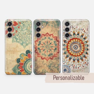 Könnte beinhalten: Drei Handyhüllen mit Mandala-Design. Die Hüllen sind beige mit roten, blauen und grünen Akzenten. Die Hüllen sind personalisierbar.
