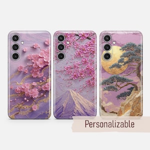 May include: Three phone cases with floral and landscape designs. The cases feature pink cherry blossoms, a mountain scene, and a tree with a full moon. The word "Personalizable" is printed on a tan banner.