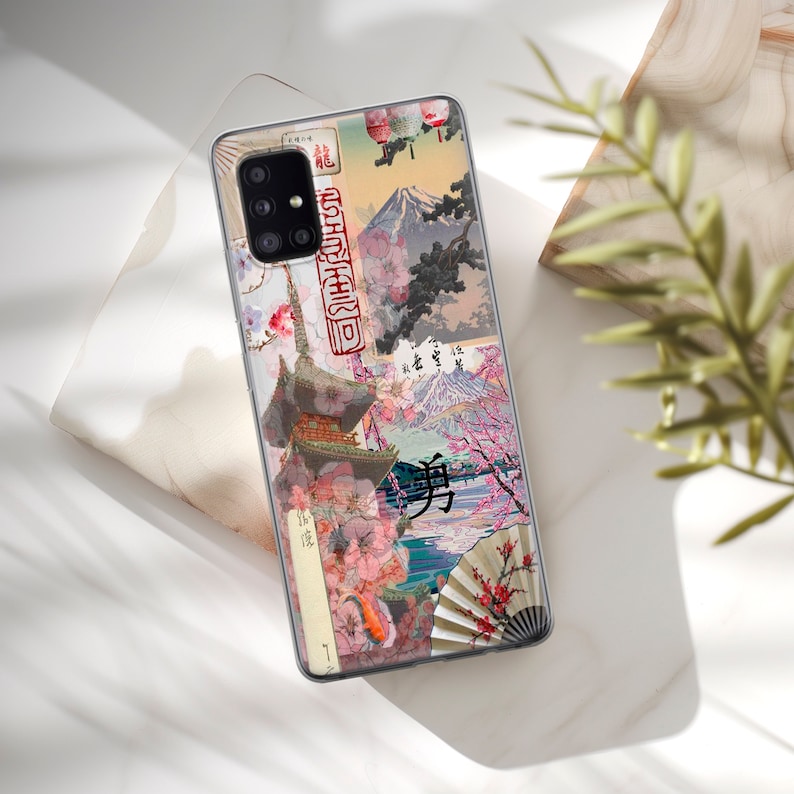 Op de afbeelding: Een telefoonhoesje met een collage van Japanse ge&iuml;nspireerde afbeeldingen, waaronder kersenbloesems, bergen en traditionele architectuur. Het hoesje heeft verschillende kleuren, waaronder roze, rood, blauw en groen.