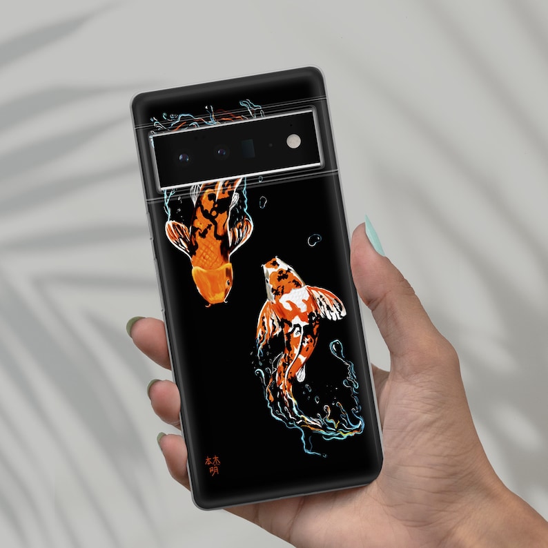 May include: Black phone case with a design of two orange and white koi fish swimming in a black background. The case has a camera lens cutout and the text "森林" in Japanese.