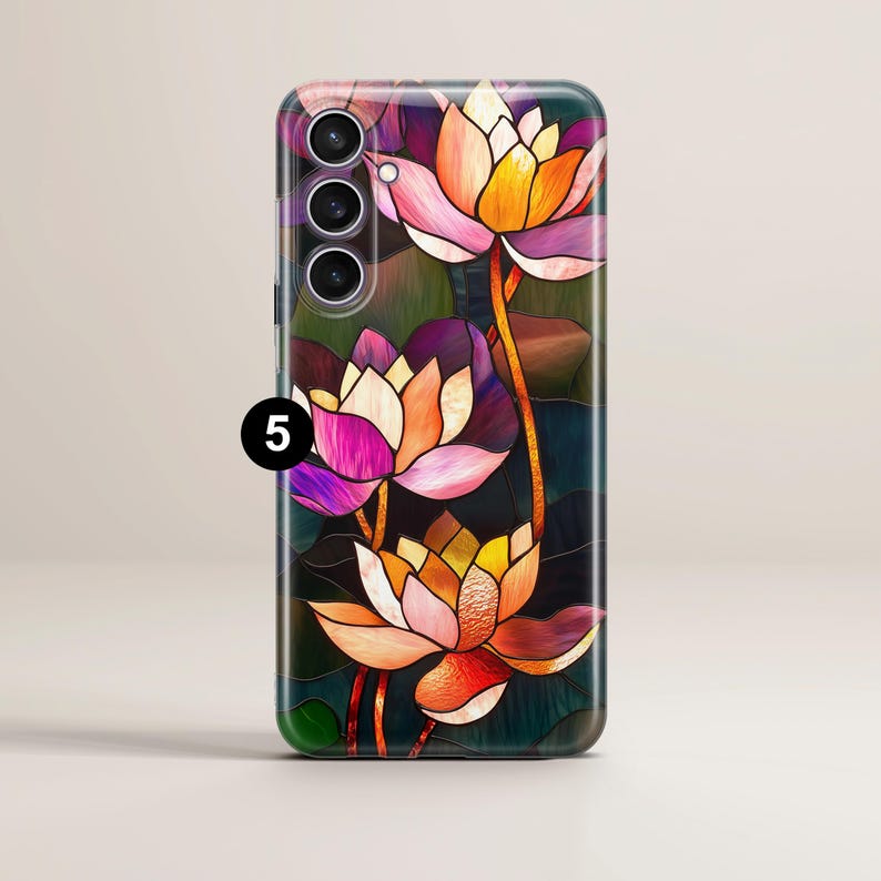 Op de afbeelding: Een telefoonhoesje met een glas-in-loodontwerp met drie roze, paarse en oranje lotusbloemen op een donkerblauwe achtergrond.