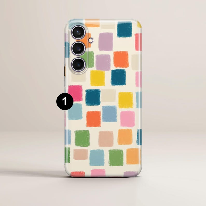 May include: A smartphone case with a colorful, abstract design. The case features a pattern of painted squares in various colors, including blue, green, yellow, orange, and pink, set against a cream background. The phone's camera lenses are visible.