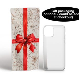 Puede incluir: Una funda de tel&eacute;fono blanca con un lazo rojo y un patr&oacute;n floral. El embalaje de regalo est&aacute; disponible en la caja.