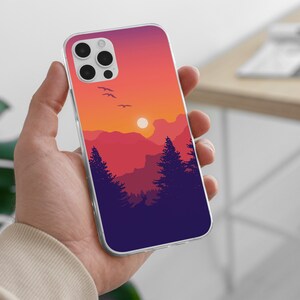 May include: A clear phone case with a sunset landscape design. The design features a silhouette of mountains, trees, and birds flying in a purple, orange, and pink sky.