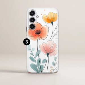 May include: A white phone case featuring a watercolor floral design. The case has a clear background with orange, peach, and yellow flowers, along with green and blue leaves. The phone case has a triple-lens camera.