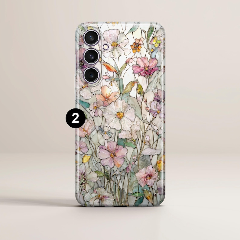 May include: A phone case featuring a floral design with white, pink, and orange flowers. The case has a glossy finish and a number 2 in a black circle. The design resembles a watercolor painting.