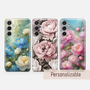 May include: Three phone cases with floral designs. The first case features blue and white flowers on a green background. The second case features pink and white flowers on a dark background. The third case features pink and white flowers on a light blue background.