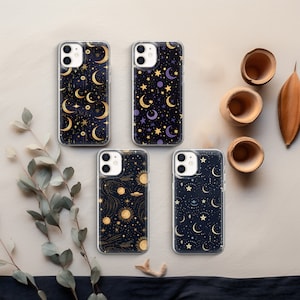 May include: Four clear phone cases with different celestial designs. Each case features a dark background with gold and purple accents. The designs include moons, stars, and planets.