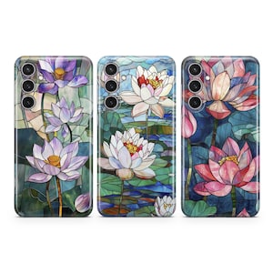 Op de afbeelding: Drie telefoonhoesjes met een glas-in-loodontwerp met roze, witte en paarse lotusbloemen op een blauwe en groene achtergrond.