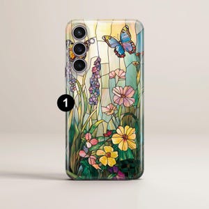 May include: A smartphone case featuring a stained-glass design with butterflies, flowers, and foliage in shades of yellow, pink, blue, and green. The case has a glossy finish and a camera module at the top.