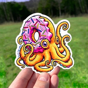 May include: A pink and yellow octopus with a donut for a head. The donut is covered in colorful sprinkles. The octopus has eight tentacles with colorful rings.