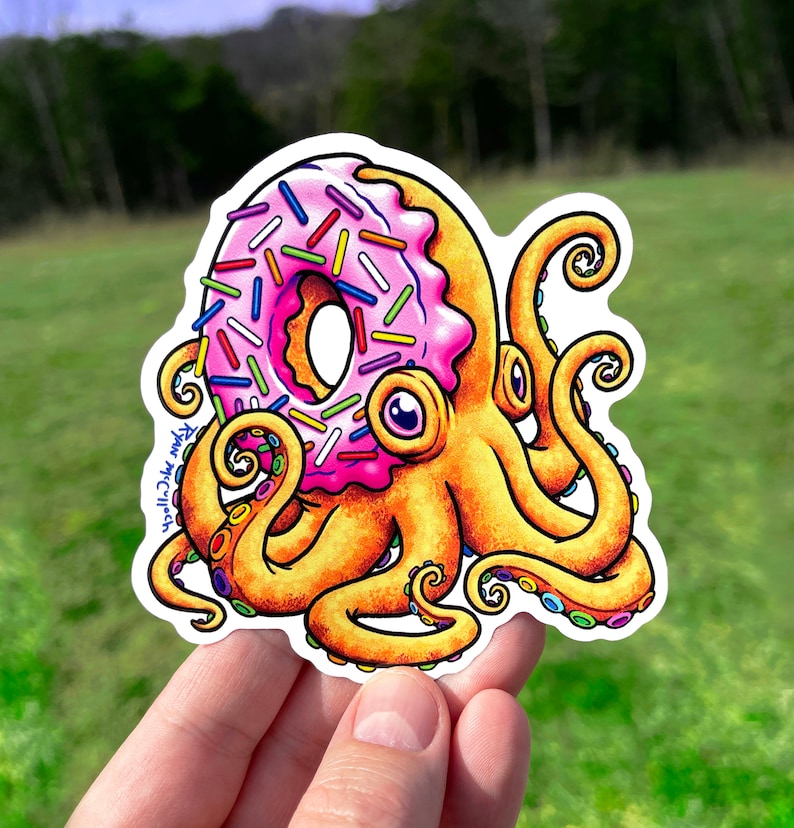 May include: A pink and yellow octopus with a donut for a head. The donut is covered in colorful sprinkles. The octopus has eight tentacles with colorful rings.