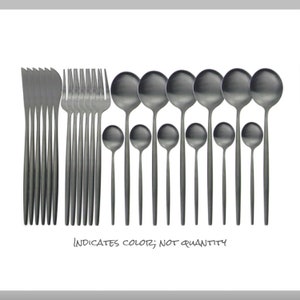 May include: A set of matte black flatware, including knives, forks, and spoons. The image shows a variety of spoon sizes. The text at the bottom reads "INDICATES COLOR; NOT QUANTITY."